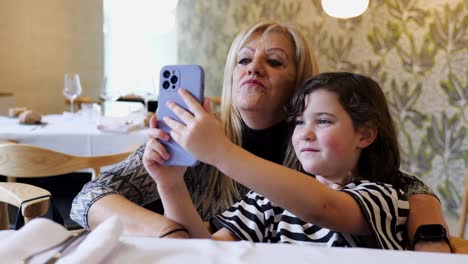 Positive-woman-and-girl-taking-selfie-on-smartphone