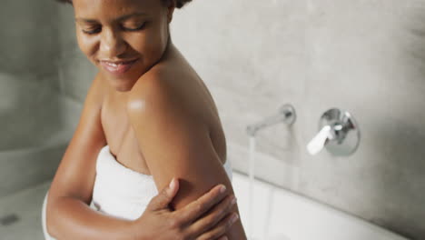 feliz mujer afroamericana preparando el baño en el baño