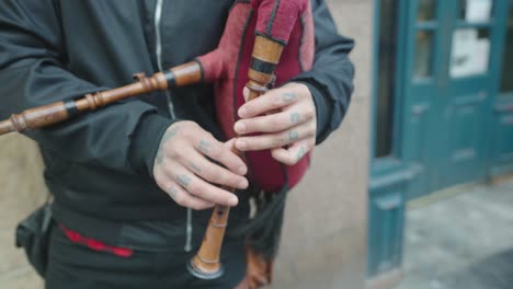 a close-up of a street performer playing the bagpipes