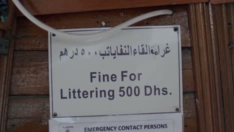 fine for littering 500 dirhams, warning sign board on boat in uae, close up