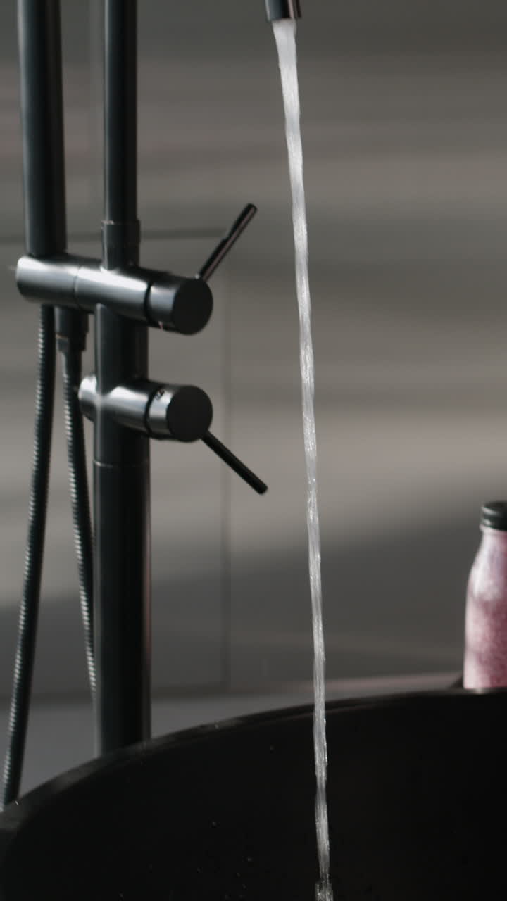Water Filling a Modern Black Vessel Sink