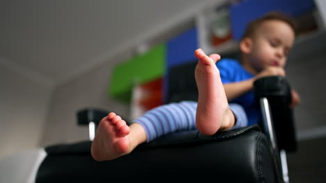 small businessman in office. cute boy sitting on a boss chair.