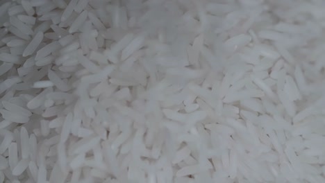 close up of white rice falling on  over a black background slow motion