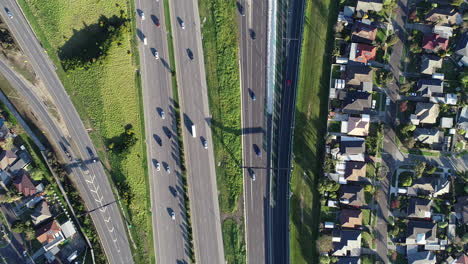 lento decente de arriba hacia abajo mirando los vehículos que se mueven al unísono a lo largo del cruce de autopistas debajo