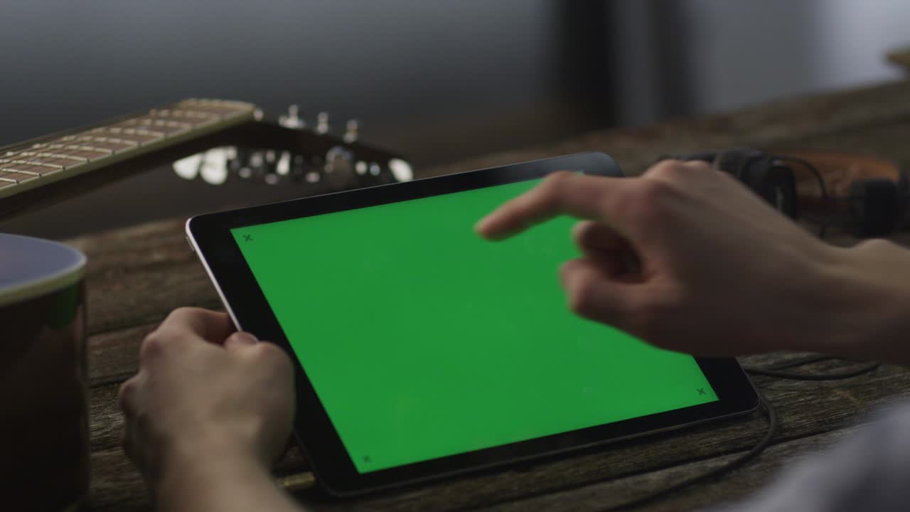 Musiker bruger tablet-pc i liggende tilstand derhjemme. Afslappet livsstil