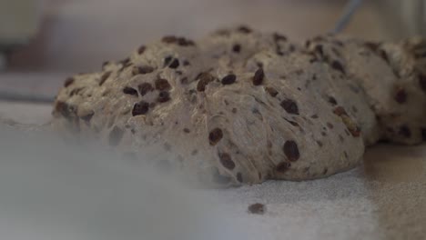 dough piece in a bakery lies on a table for baking with raisins