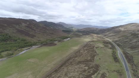 Luftaufnahme-Von-Links-Nach-Rechts-über-Der-Hauptstraße-A9-Und-Der-Eisenbahn-In-Der-Nähe-Von-Dalwhinnie-In-Den-Schottischen-Highlands