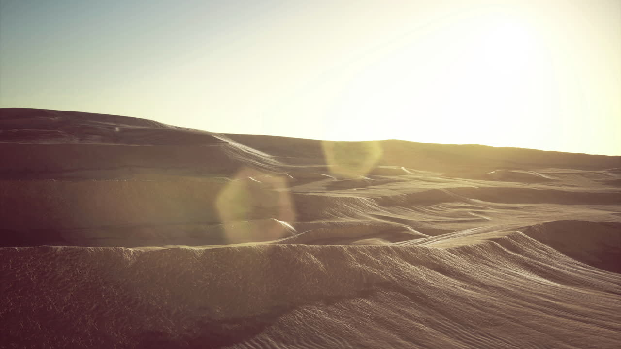Dunes illuminated by golden sunlight at dusk in an expansive desert landscape