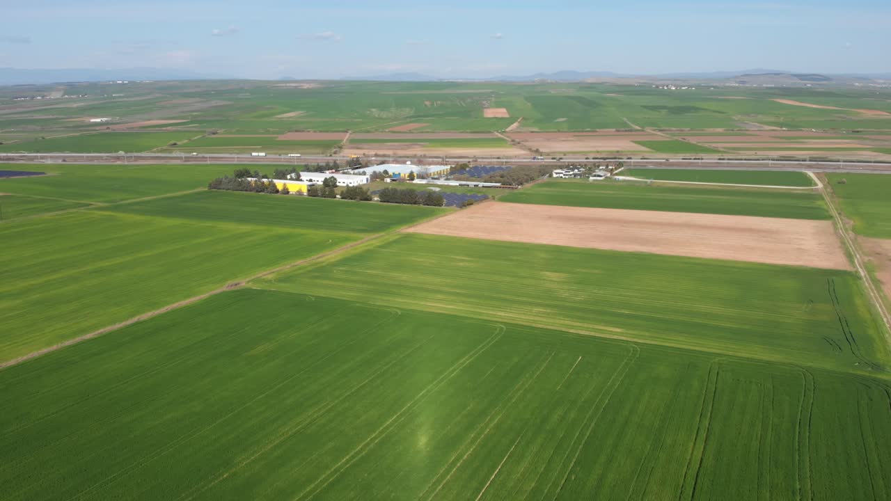 Aerial shot vibrant green agricultural green fields close up, in the countryside on a spring sunny day