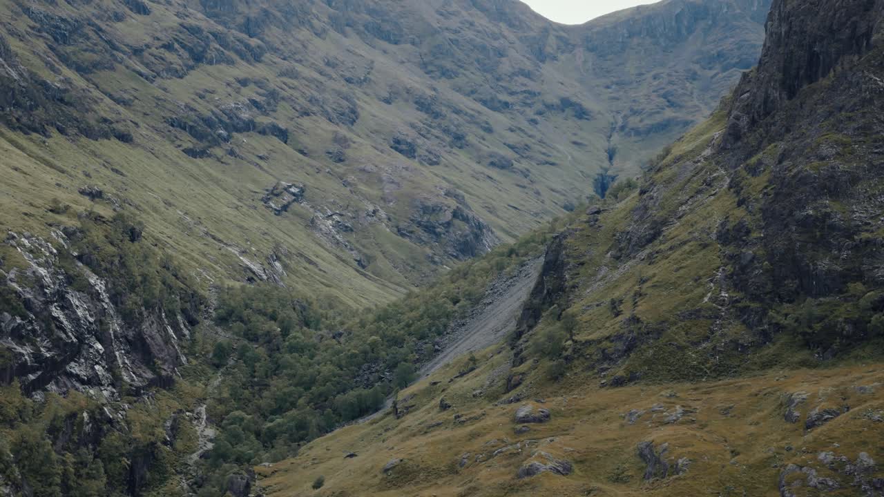 Ripresa ravvicinata con movimento circolare a sinistra delle Tre Sorelle vicino a Glencoe, montagne aspre e vivaci.