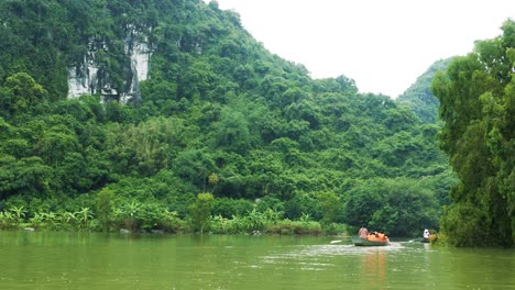 Boat-Tour-through-Ninh-Binh-Bird-Park-in-Vietnam-with-Karst-Mountains-in-the-Background