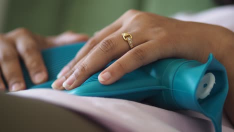 woman using a hot water bottle for pain relief