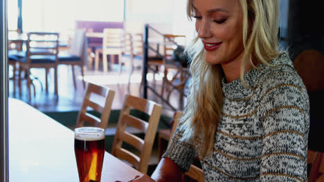 schöne frau mit mobiltelefon am bar-schalter 4k