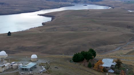 Drone-reveal-beauty-of-nature,-snowy-mountain-peaks,-lake-and-observatory-dome