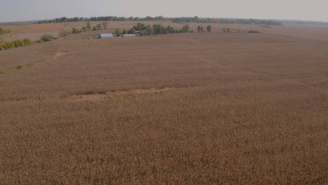 flyover farmland in the midwest past a beautiful farm house and towards a country road