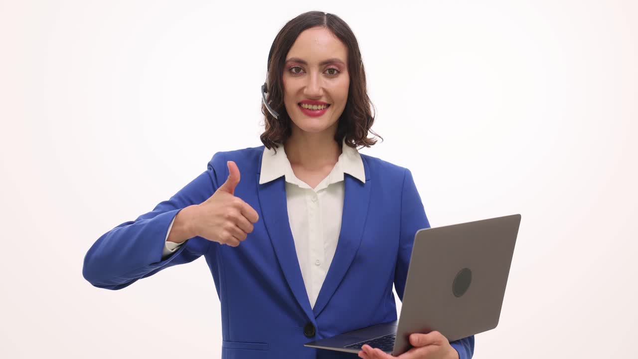 Businesswoman with headset and laptop giving thumbs up