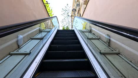 escalera mecánica ascendente a una calle soleada