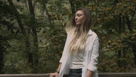 Young-millennial-female-standing-alone-in-the-woods-enjoying-fresh-air-nature