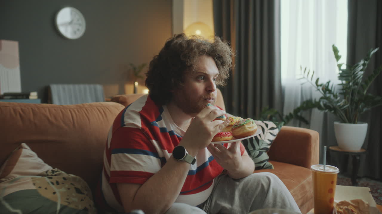 Man Eating Donuts on a Couch