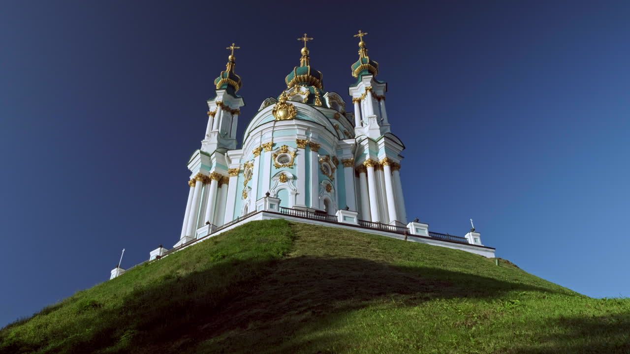 Camera rises from behind wall to reveal St Andrews Church Kiev in beautiful morning light