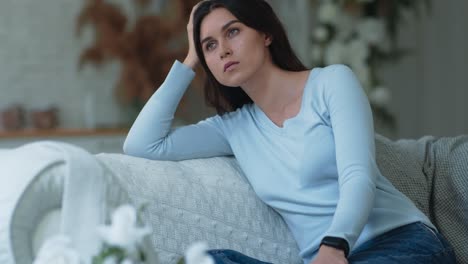 woman sitting on a sofa looking pensive