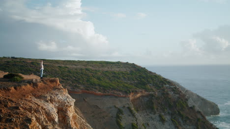 Tourist-woman-enjoying-sea-rocky-landscape.-Tranquil-lady-relaxing-on-ocean