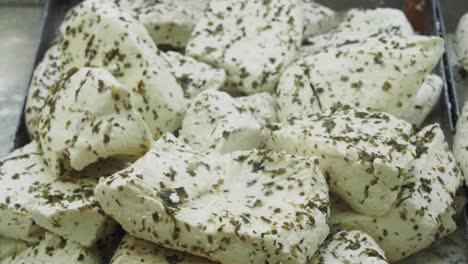 closeup of fresh feta cheese blocks with herbs