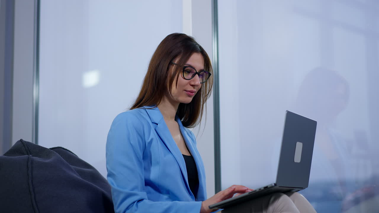 mujer trabajando en una computadora portátil en una oficina moderna