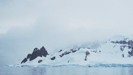 winter mountains and glacier on coast, coastal scenery in antarctica, landscape and seascape with glacier ice and ocean sea water, antarctic peninsula beautiful dramatic mountain coastline scene