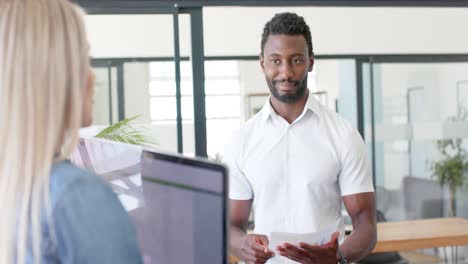 happy diverse business people discussing work with laptop in office in slow motion