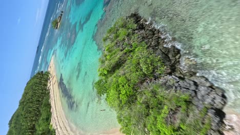 fpv filmado en la playa ermitaño mar en samana, república dominicana- vista vertical