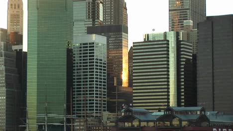 Die-Kamera-Schwenkt-Vom-Ufer-Der-South-Street-Zum-Seehafen-Bis-Zu-Den-Gipfeln-Der-Umliegenden-Wolkenkratzer,-Einschließlich-Des-Empire-State-Buildings-In-Der-Goldenhour