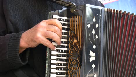 primer plano de la mano de un hombre tocando un acordeón