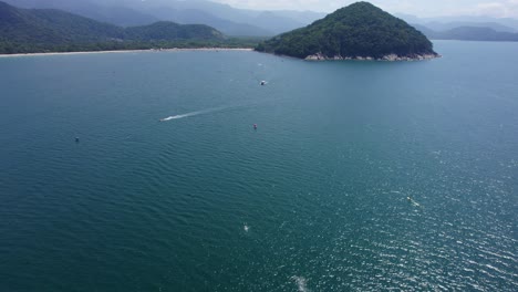 Aerial-view-of-boats-driving-at-a-swimming-competition,-in-Barra-Do-Sahy,-sunny-Brazil