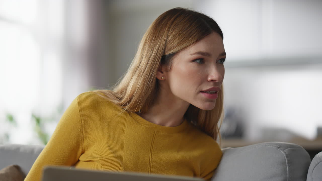 Smiling woman working computer at sofa closeup. Lady looking boyfriend laptop