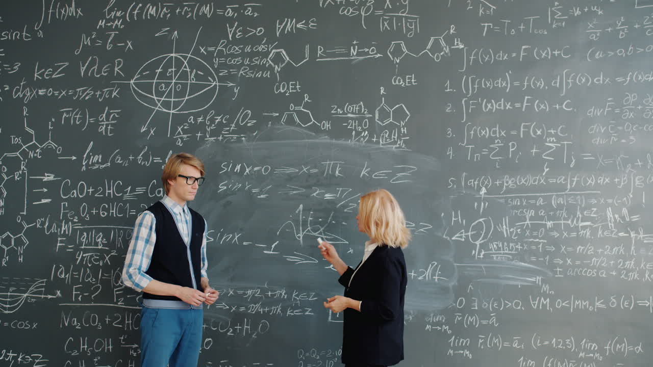 Teacher and student discussing mathematics on a chalkboard