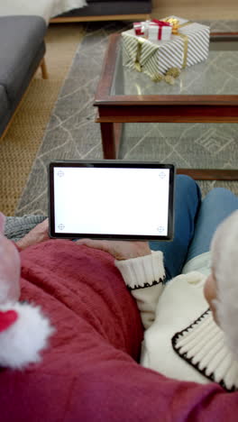 vertical video of senior caucasian couple using tablet with copy space on screen, slow motion