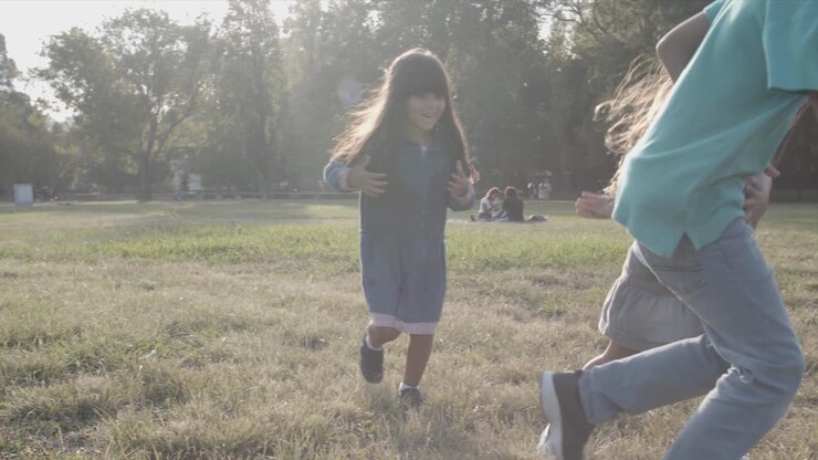 Bambini felici che giocano a calcio nel prato
