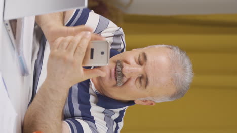 Video-Vertical-De-Un-Anciano-Trabajador-De-Oficina-Hablando-Por-Teléfono-Facetime-Felizmente.