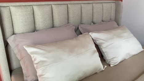 showing a bedroom with soft and comfortable pillows and mattresses with a simple, aesthetic and elegant decoration theme.