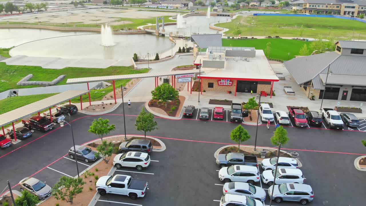 사람들이 와서 왼쪽으로 천천히 이동하는 다운타운 레스토랑은 세 개의 큰 분수와 배경에 그들의 수영장과 함께 다운타운 개발 센터의 일부입니다