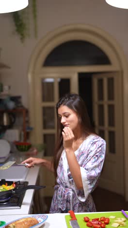 mujer cocinando en su cocina por la noche