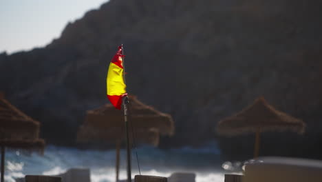 Bandera-Española-Ondeando-En-Una-Playa-En-Un-Día-Ventoso