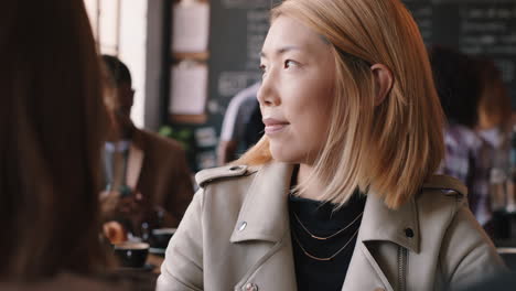 Hermosa-Mujer-Asiática-Usando-Un-Teléfono-Inteligente-Tomando-Café-En-Una-Cafetería-Enviando-Mensajes-De-Texto-Compartiendo-Mensajes-En-Las-Redes-Sociales-Disfrutando-De-La-Tecnología-Móvil