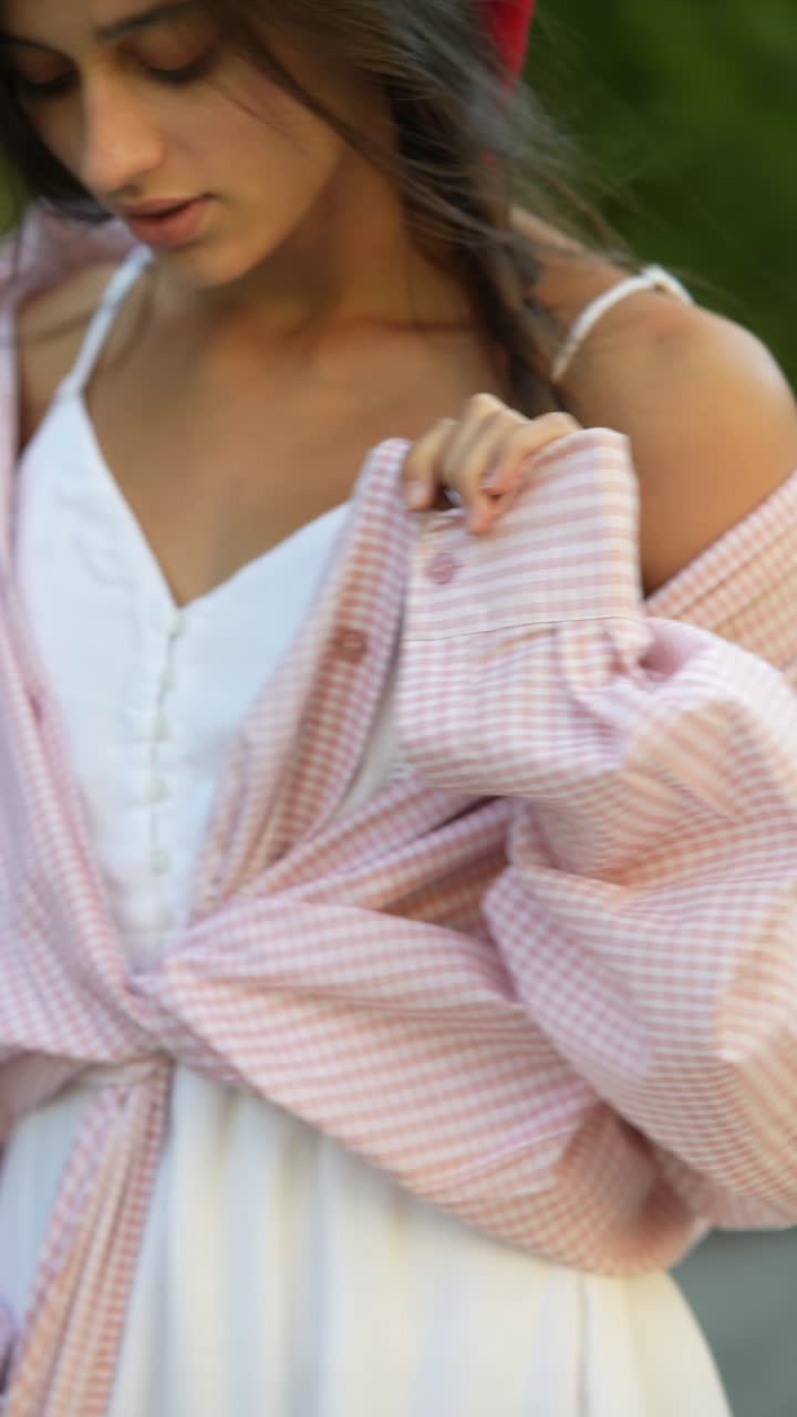 mujer con un vestido de camisa a cuadros rosa y blanco