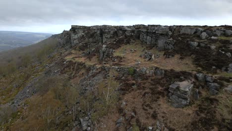 Aerial-drone-footage-revealing-a-dramatic,-beautiful-rock-formation-at-Curbar-Edge-in-the-Peak-District,-UK