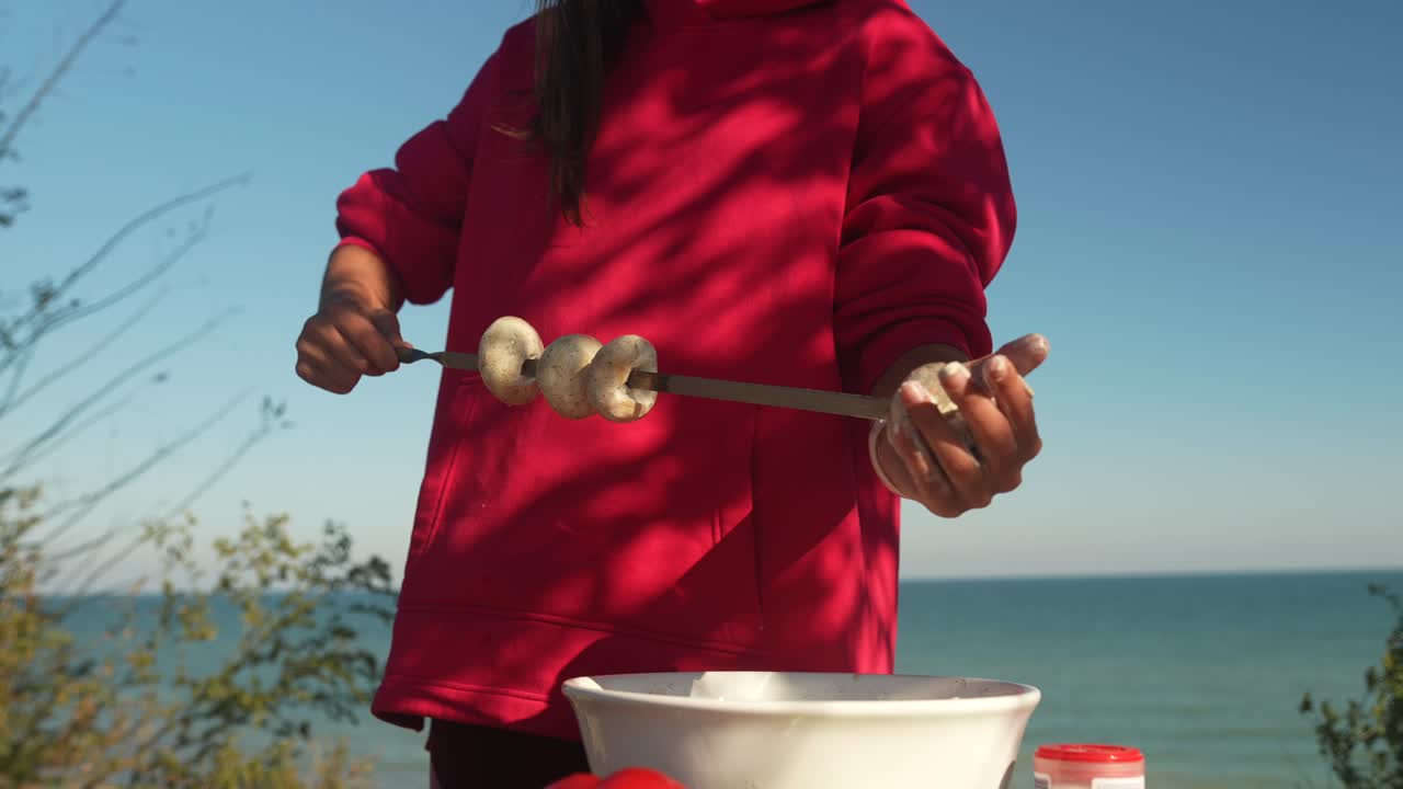 해변에서 버섯 스피어를 준비하는 소녀