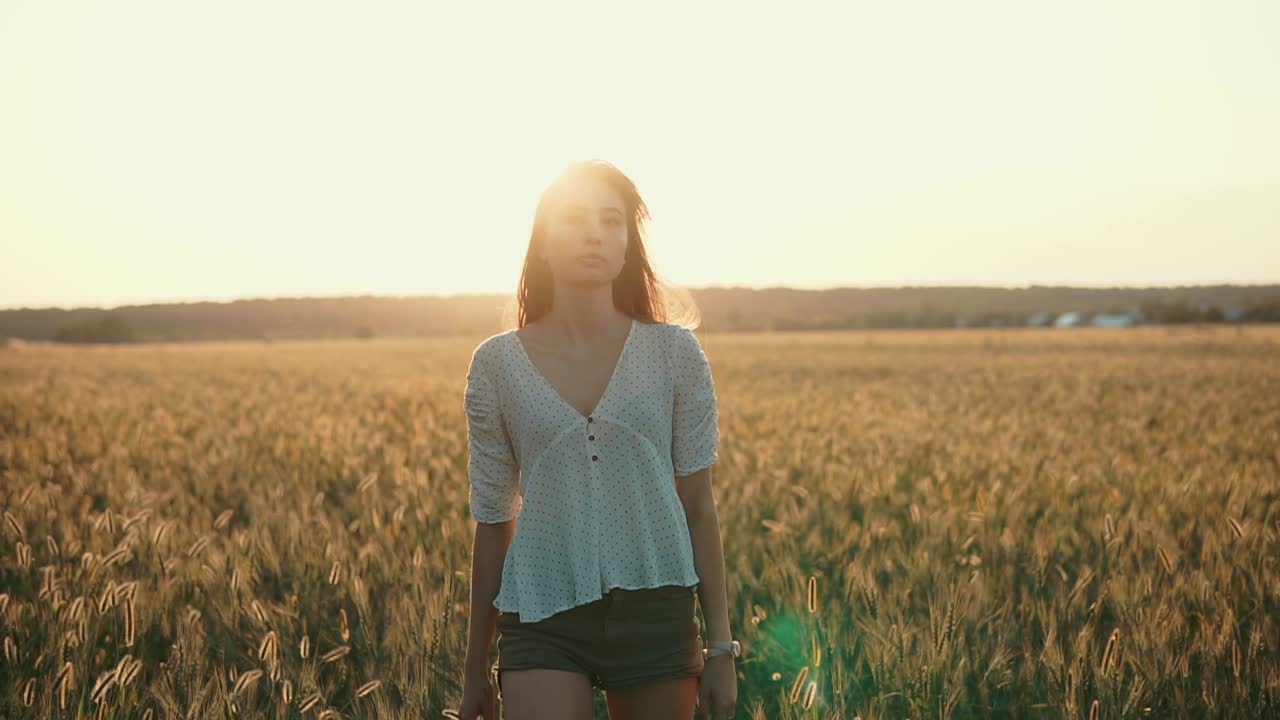 해가 지는 동안 밀에서 고 있는 여자