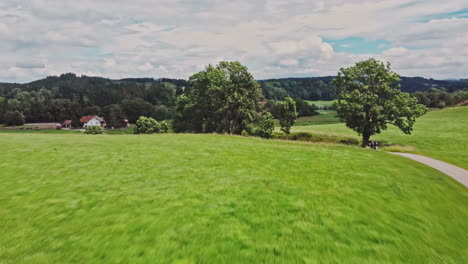 Drone-shot-of-the-peaceful-countryside-of-Allgäu,-Germany-with-its-lush-green-meadows-and-farm-houses