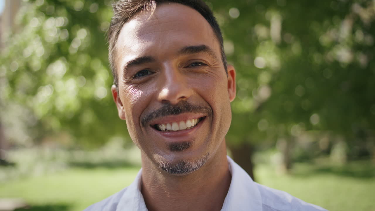 Portrait  businessman smiling camera at green city. Man face posing